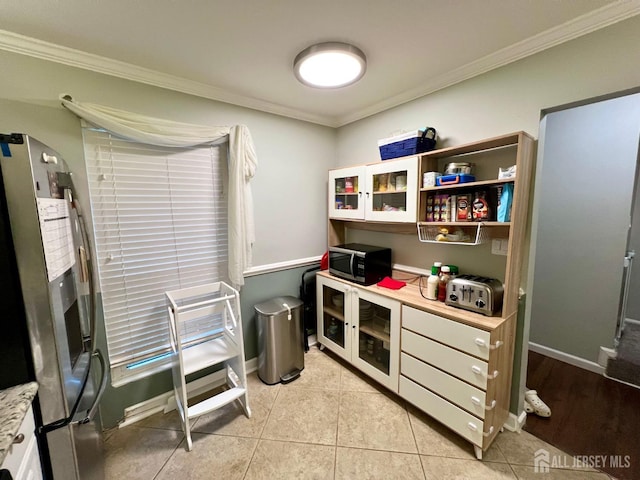 kitchen featuring white cabinetry, light tile patterned floors, crown molding, and appliances with stainless steel finishes