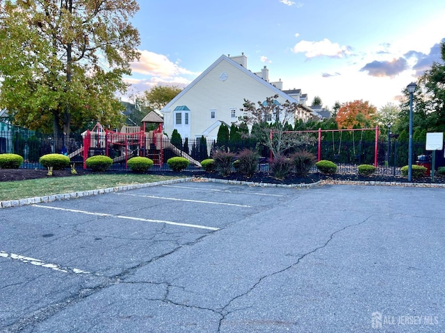 view of car parking featuring a playground