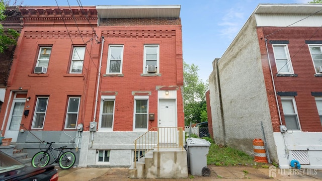 townhome / multi-family property featuring brick siding and cooling unit