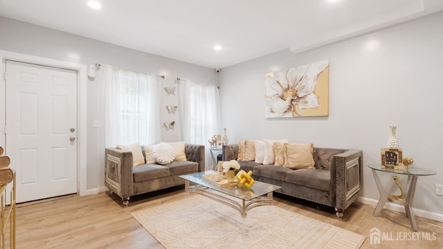 living room featuring light wood-type flooring, baseboards, and recessed lighting
