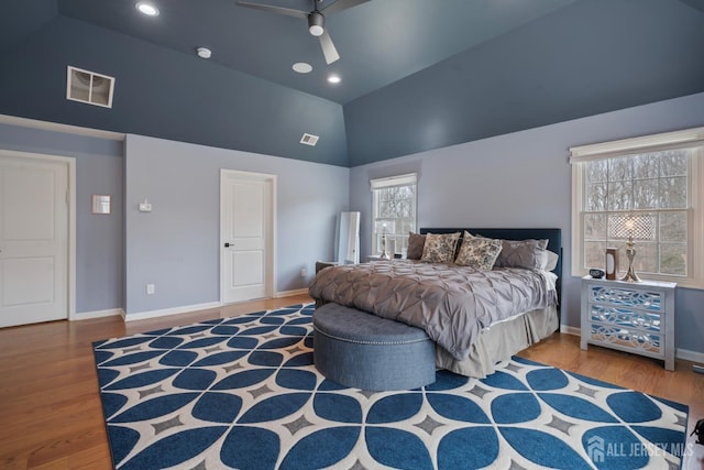 bedroom featuring lofted ceiling, wood finished floors, visible vents, and baseboards