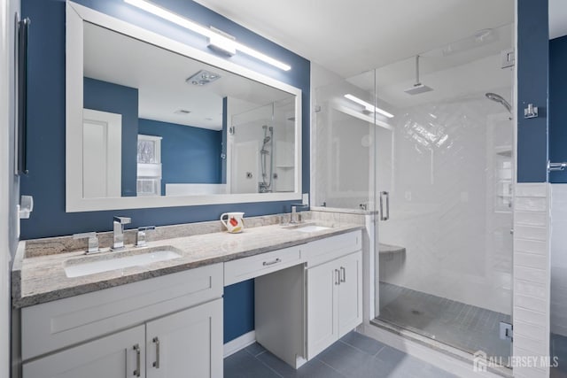 bathroom with tile patterned flooring, a shower stall, double vanity, and a sink