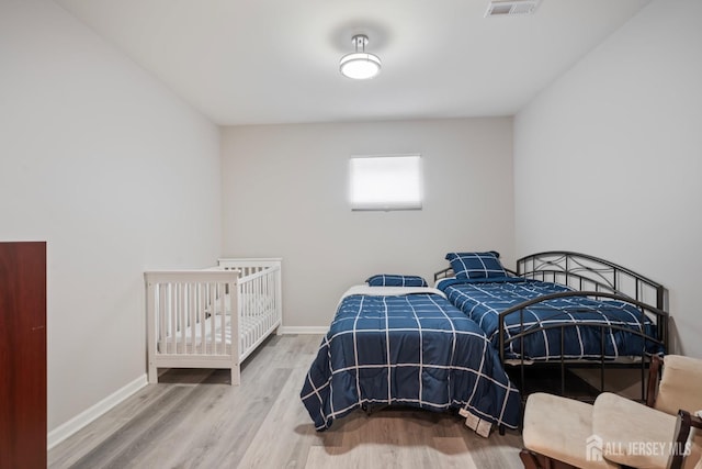 bedroom with visible vents, baseboards, and wood finished floors