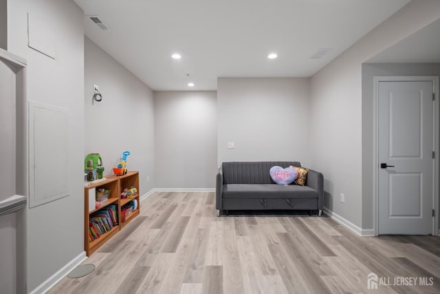 living area with visible vents, recessed lighting, light wood-type flooring, and baseboards