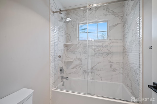 full bathroom with toilet and shower / bath combination with glass door