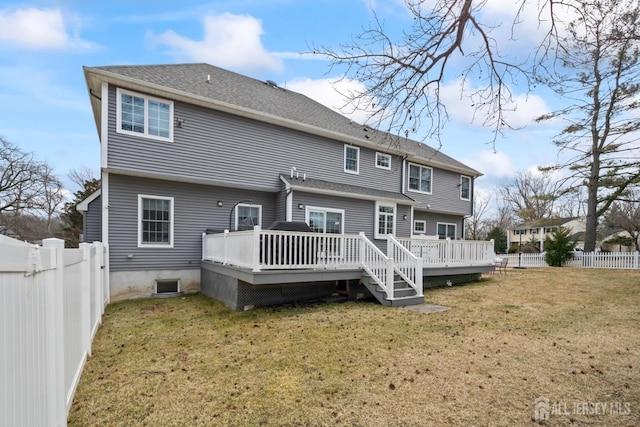 rear view of property featuring a yard, a deck, and a fenced backyard