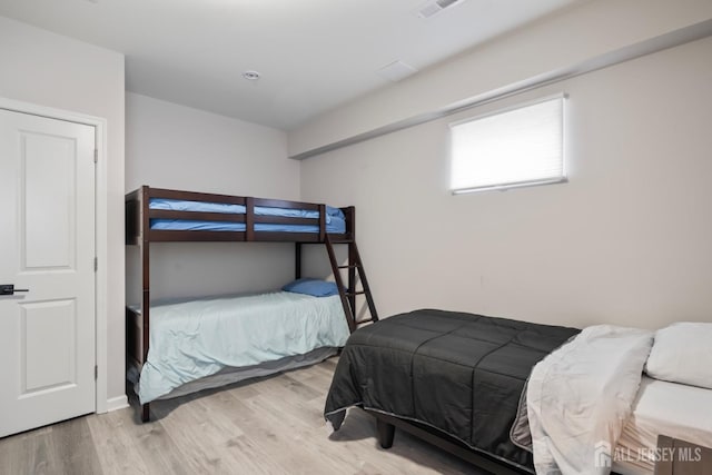 bedroom featuring wood finished floors and visible vents