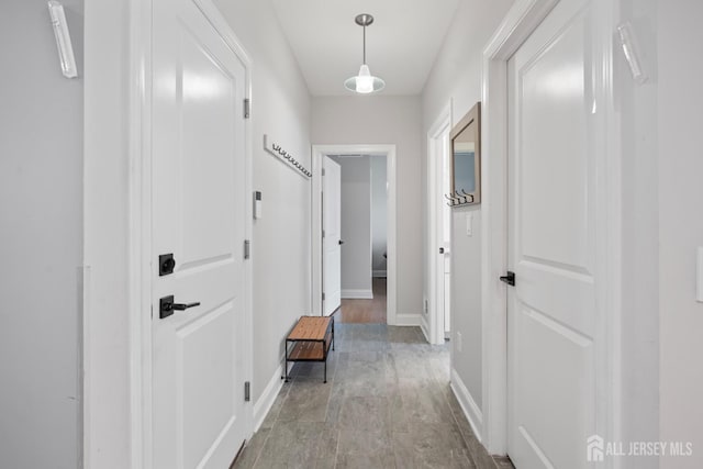 hall featuring light wood-style floors and baseboards