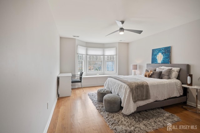 bedroom with visible vents, ceiling fan, baseboards, and light wood-style floors