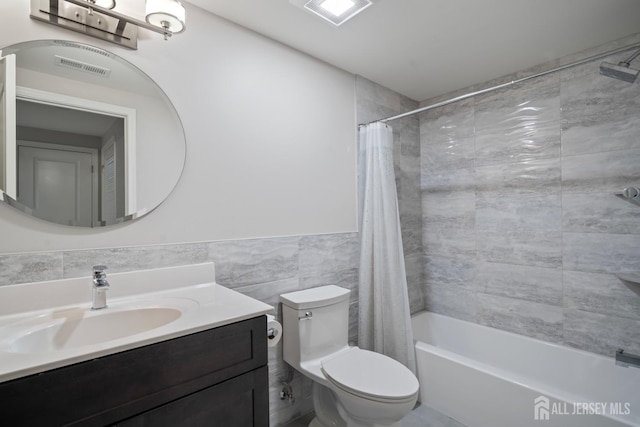 bathroom featuring visible vents, toilet, tile walls, and vanity