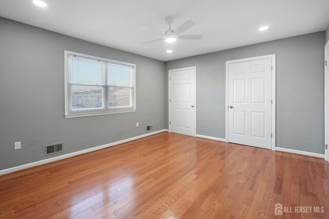 unfurnished bedroom with ceiling fan and light wood-type flooring