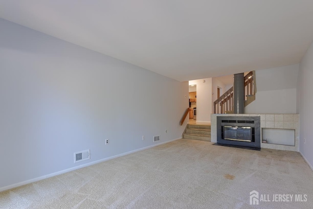 1027 Schmidt Ln, North Brunswick, NJ 08902 - unfurnished living room with light carpet, stairs, and a fireplace with flush hearth