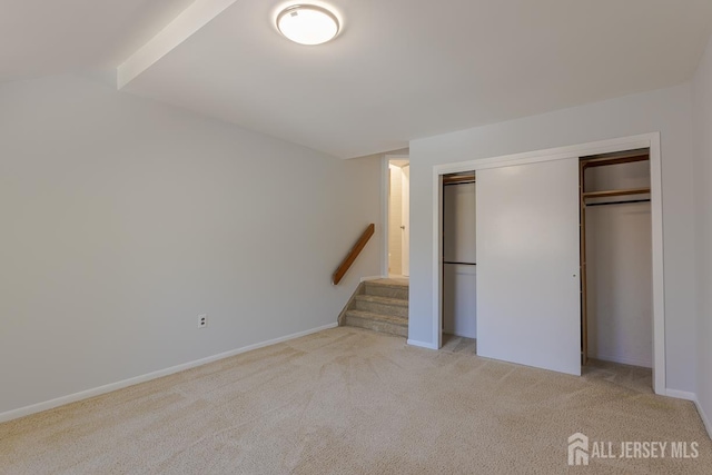 1027 Schmidt Ln, North Brunswick, NJ 08902 - unfurnished bedroom featuring light colored carpet, a closet, and vaulted ceiling