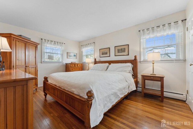 341 Ellis Pkwy, Piscataway, NJ 08854 - bedroom featuring wood finished floors, baseboard heating, and baseboards
