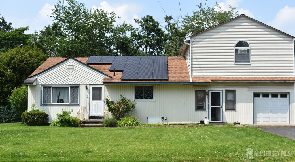 126 Lakeside Dr, Piscataway, NJ 08854 - view of front of home featuring a front lawn, solar panels, roof with shingles, and an attached garage