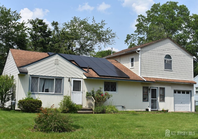 126 Lakeside Dr, Piscataway, NJ 08854 - back of house featuring solar panels, a yard, an attached garage, and a shingled roof