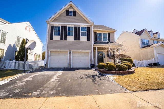 view of front of home featuring aphalt driveway, fence, and an attached garage