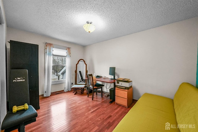 office space featuring a textured ceiling, baseboards, and wood finished floors