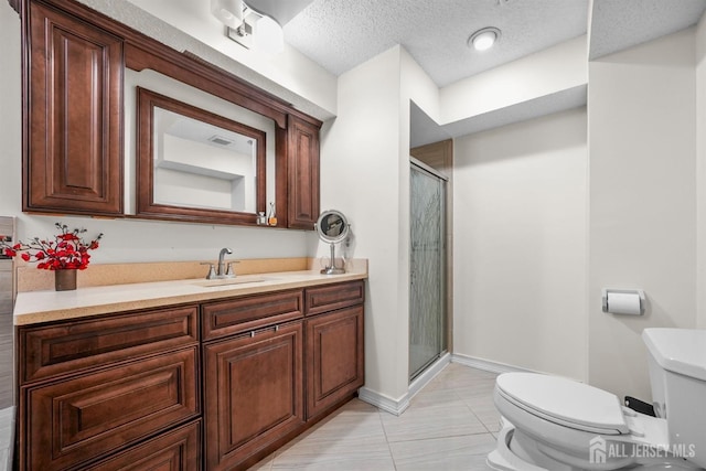 bathroom with a textured ceiling, toilet, vanity, baseboards, and a stall shower