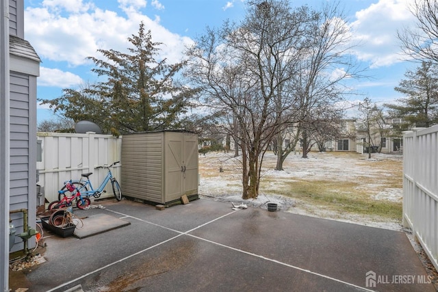 view of yard featuring a storage shed, fence, an outbuilding, and a patio