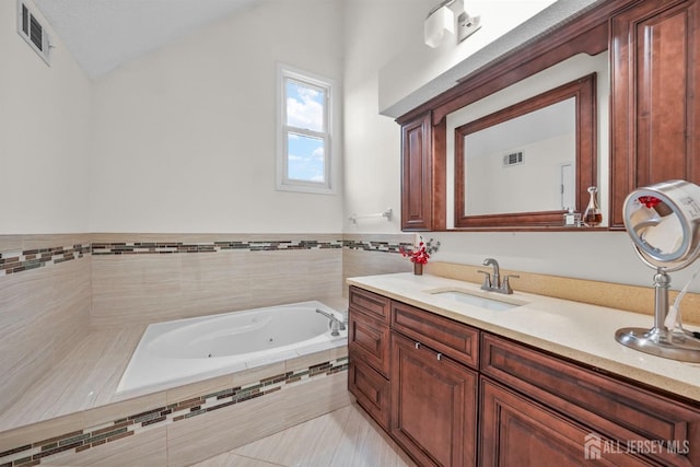 full bathroom with lofted ceiling, visible vents, a tub with jets, and vanity