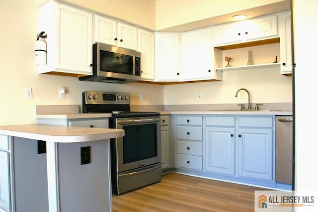 100 John T O Leary Blvd Unit 311, South Amboy, NJ 08879 - kitchen featuring appliances with stainless steel finishes, a peninsula, a sink, open shelves, and light countertops