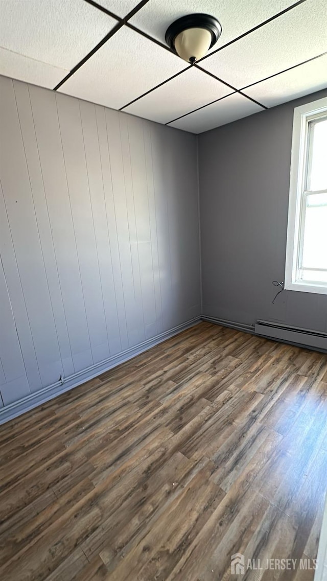 79 W 18th St, Bayonne, NJ 07002 - empty room with dark wood-type flooring, baseboard heating, and a textured ceiling