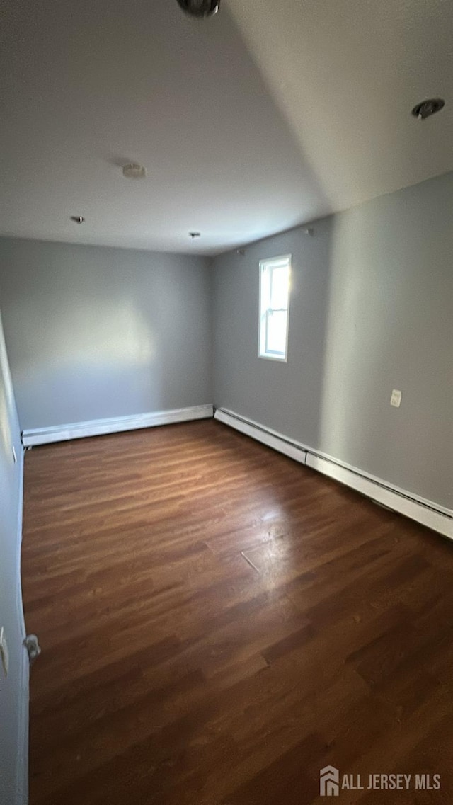 79 W 18th St, Bayonne, NJ 07002 - empty room featuring baseboard heating and dark wood-style flooring