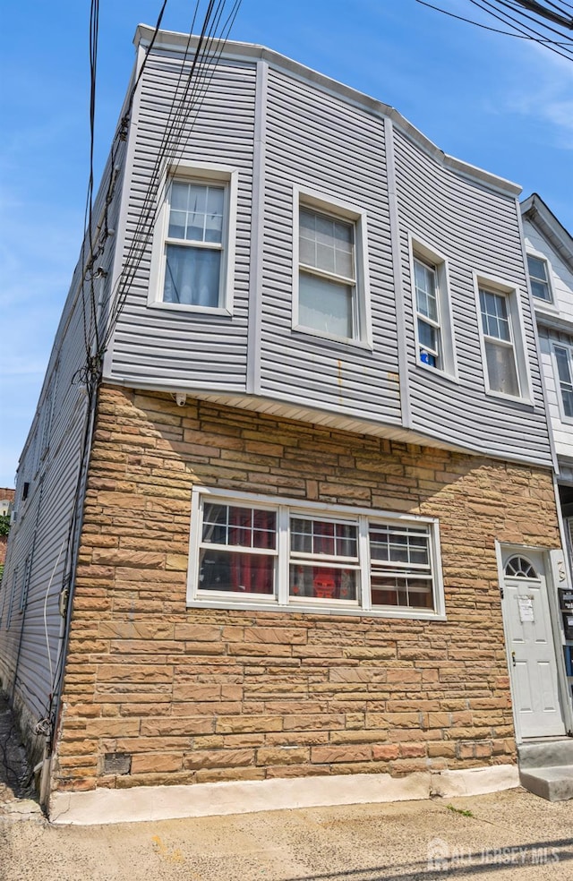 79 W 18th St, Bayonne, NJ 07002 - view of side of home with stone siding