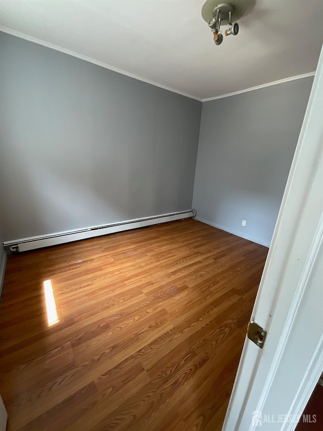 79 W 18th St, Bayonne, NJ 07002 - empty room featuring a baseboard heating unit, crown molding, and wood finished floors
