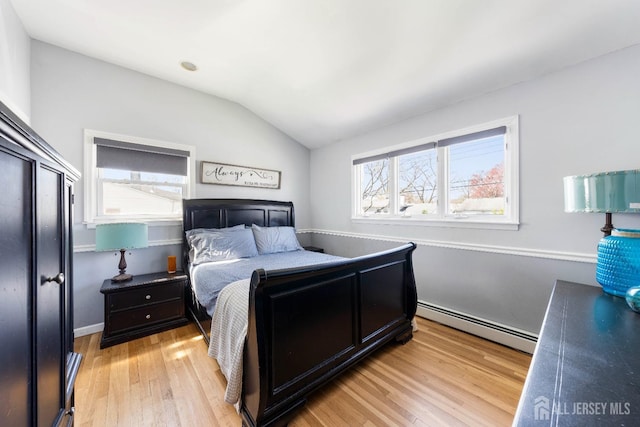 bedroom featuring a baseboard radiator, light wood-style flooring, and vaulted ceiling