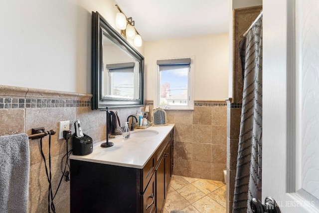 bathroom with tile walls, wainscoting, and vanity