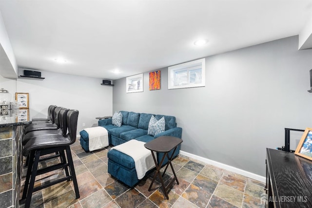 living room featuring baseboards, recessed lighting, and stone tile flooring