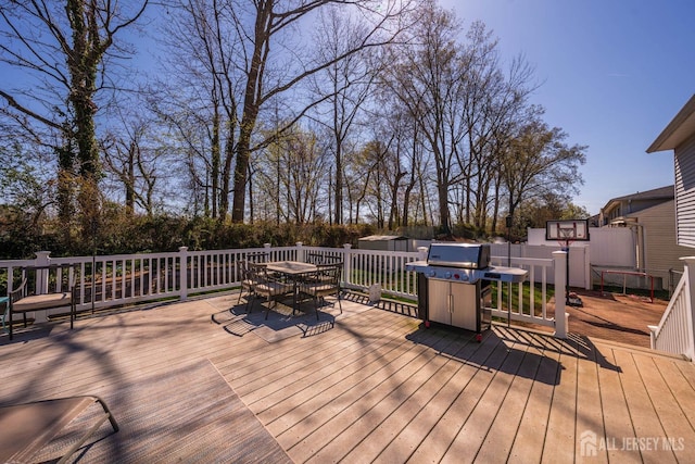deck featuring grilling area, fence, and outdoor dining area