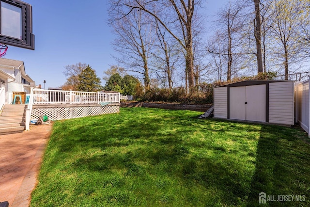 view of yard featuring a storage shed, a deck, and an outdoor structure