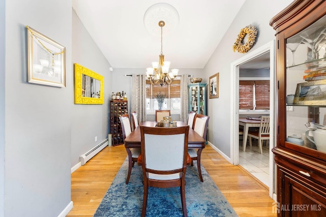 dining area featuring baseboards, a notable chandelier, baseboard heating, and lofted ceiling