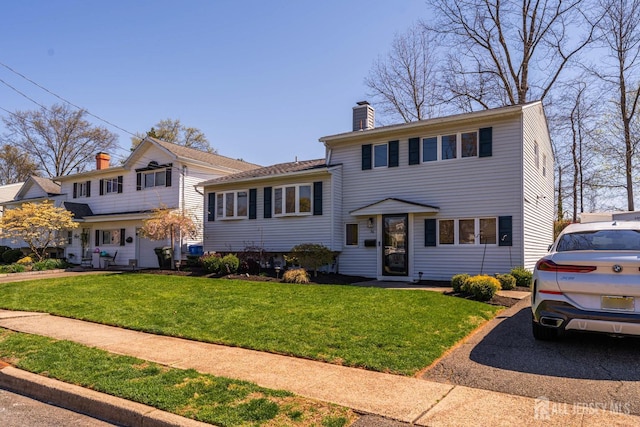 split level home with a chimney and a front yard