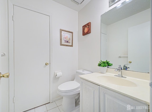 bathroom featuring tile patterned floors, vanity, a textured ceiling, and toilet