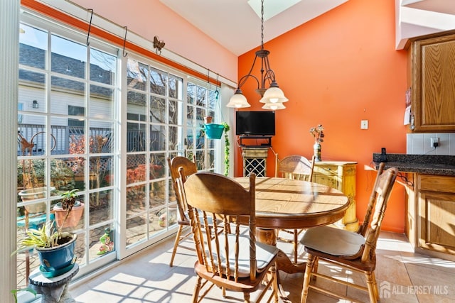 dining room with vaulted ceiling and light tile patterned floors