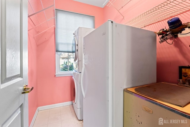 laundry area with laundry area, stacked washing maching and dryer, and baseboards