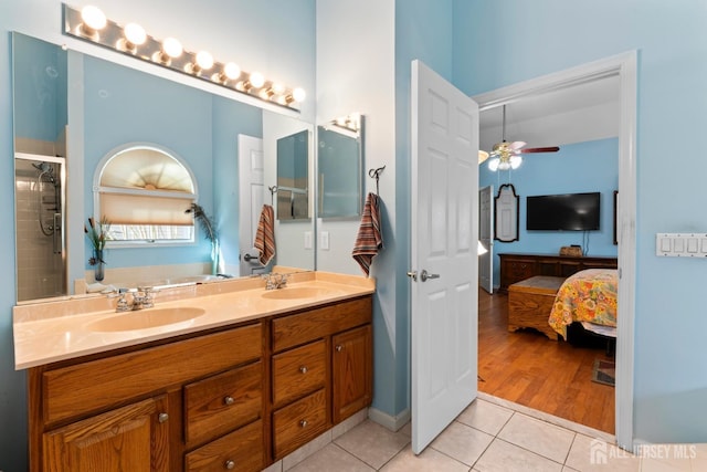 full bathroom featuring double vanity, a ceiling fan, ensuite bathroom, tile patterned floors, and a sink