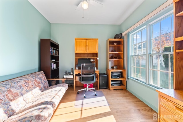 office with light wood-type flooring, a ceiling fan, baseboards, and a wealth of natural light