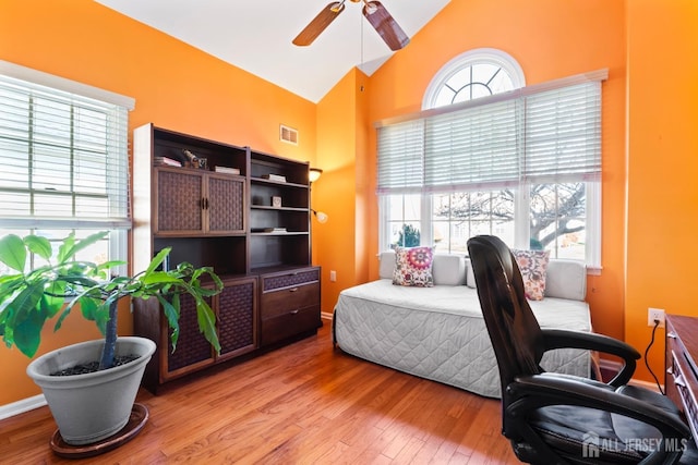 bedroom featuring light wood-style floors, multiple windows, vaulted ceiling, and visible vents