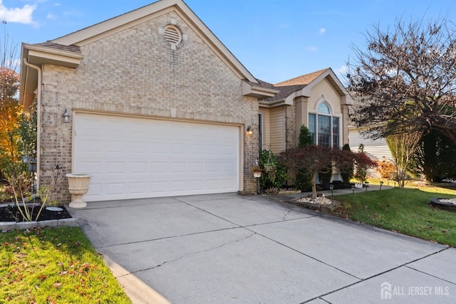 ranch-style house featuring a garage, concrete driveway, brick siding, and a front lawn