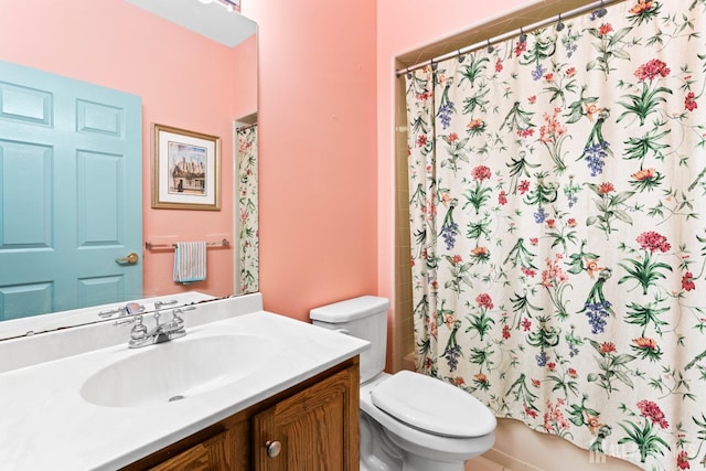 bathroom featuring curtained shower, vanity, and toilet