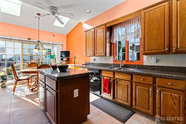 kitchen featuring vaulted ceiling with skylight, black dishwasher, a sink, and backsplash