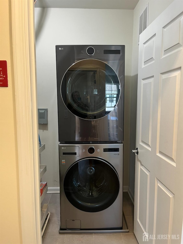 1425 Hudson Cir, Highland Park, NJ 08904 - laundry room featuring estacked washer and dryer, tile patterned floors, and baseboards