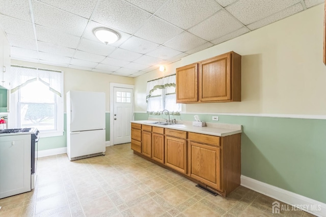 55 Leland Ave, Plainfield, NJ 07062 - kitchen with white appliances, brown cabinetry, a paneled ceiling, and light countertops