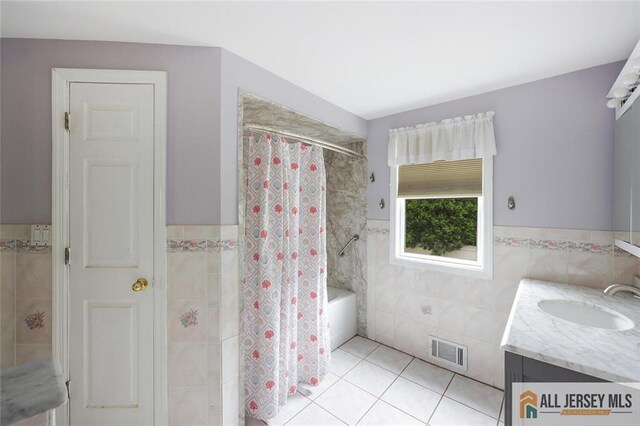 53 Second St, Edison, NJ 08837 - bathroom featuring tile walls, tile patterned floors, wainscoting, vanity, and shower / tub combo with curtain