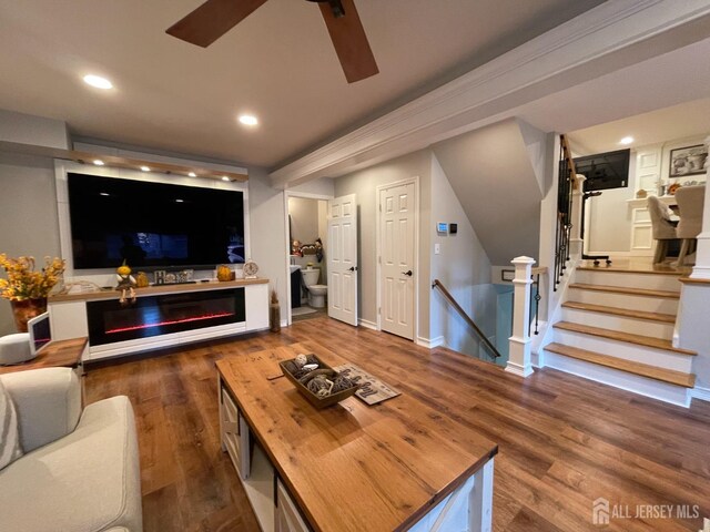 living room with ceiling fan and dark wood-type flooring